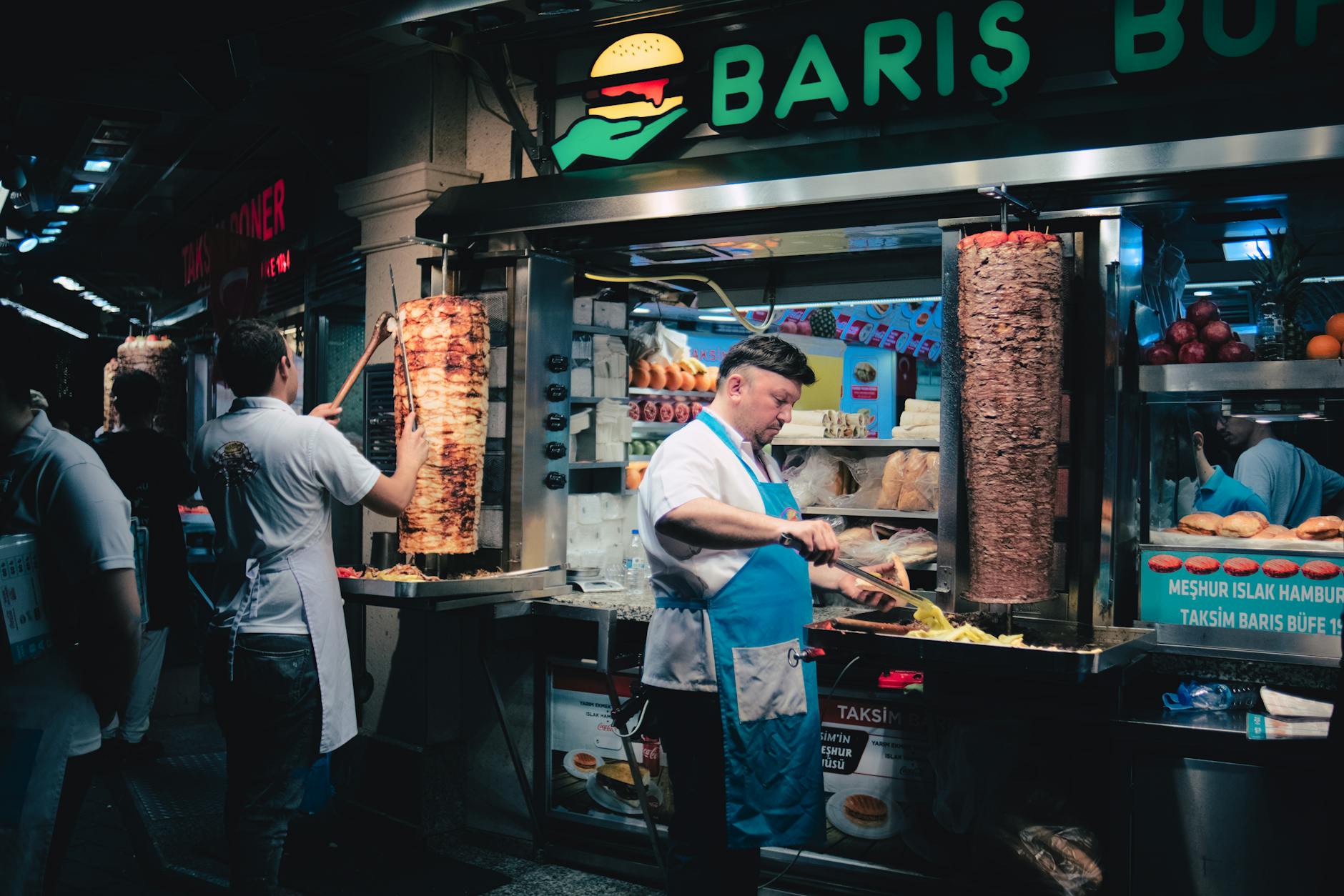 Cocineros preparando carne de döner artesanal en un puesto tradicional de la calle Taksim.