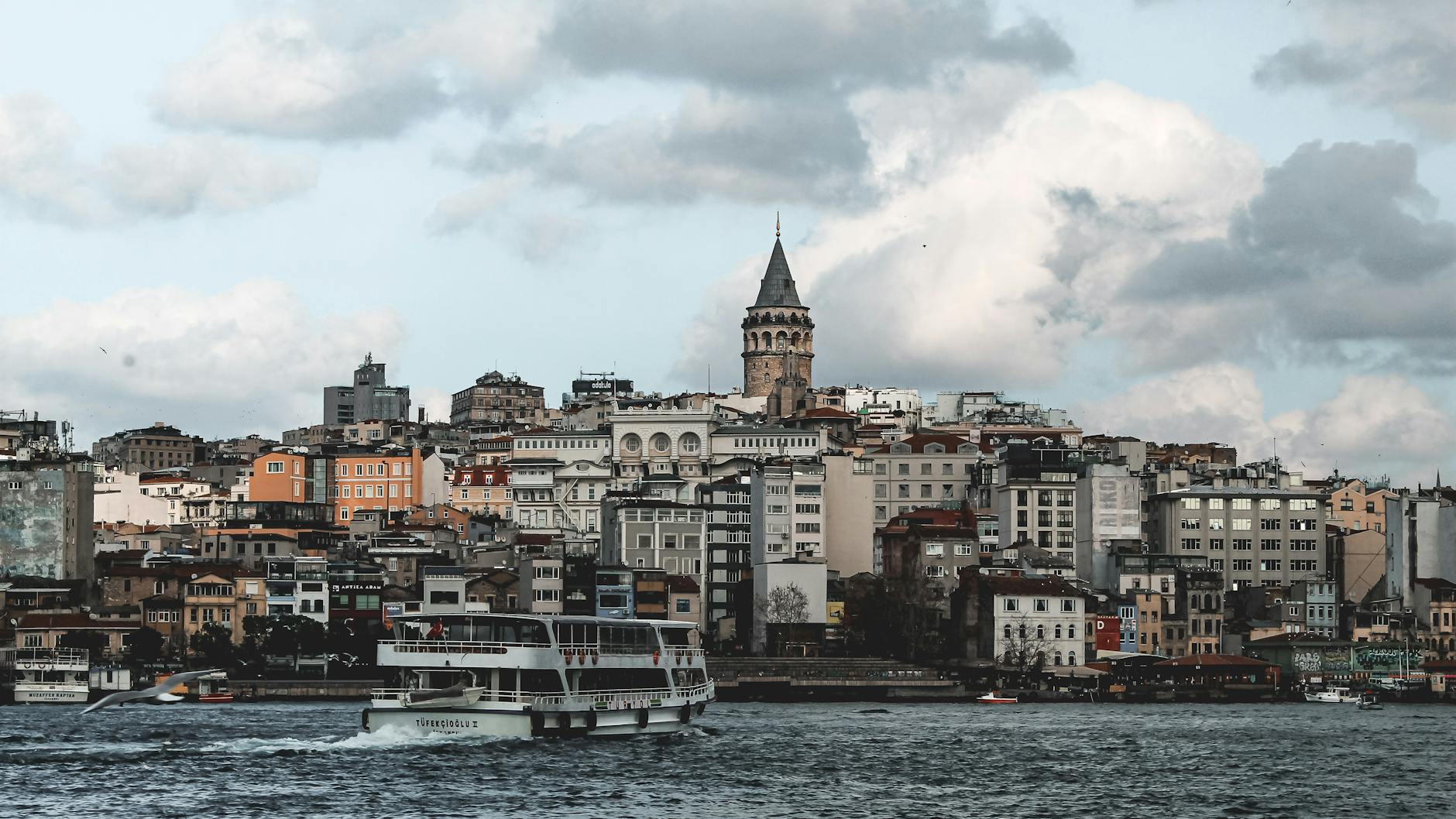 Un ferry de transporte público navega frente a la emblemática Torre de Gálata en Estambul.