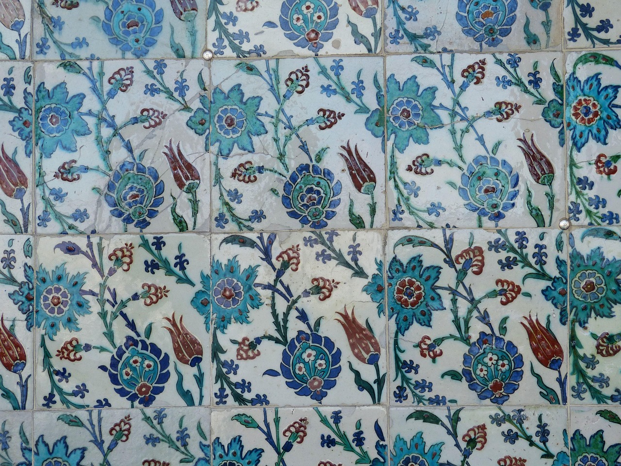 Mosaico de azulejos tradicionales con motivos florales en las paredes del palacio.