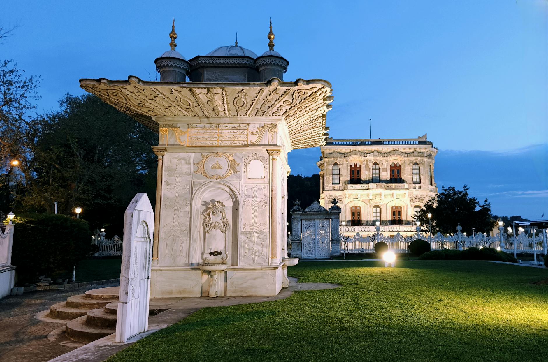 Fuente de mármol iluminada junto al Palacio de Küçüksu durante una tarde en Estambul.