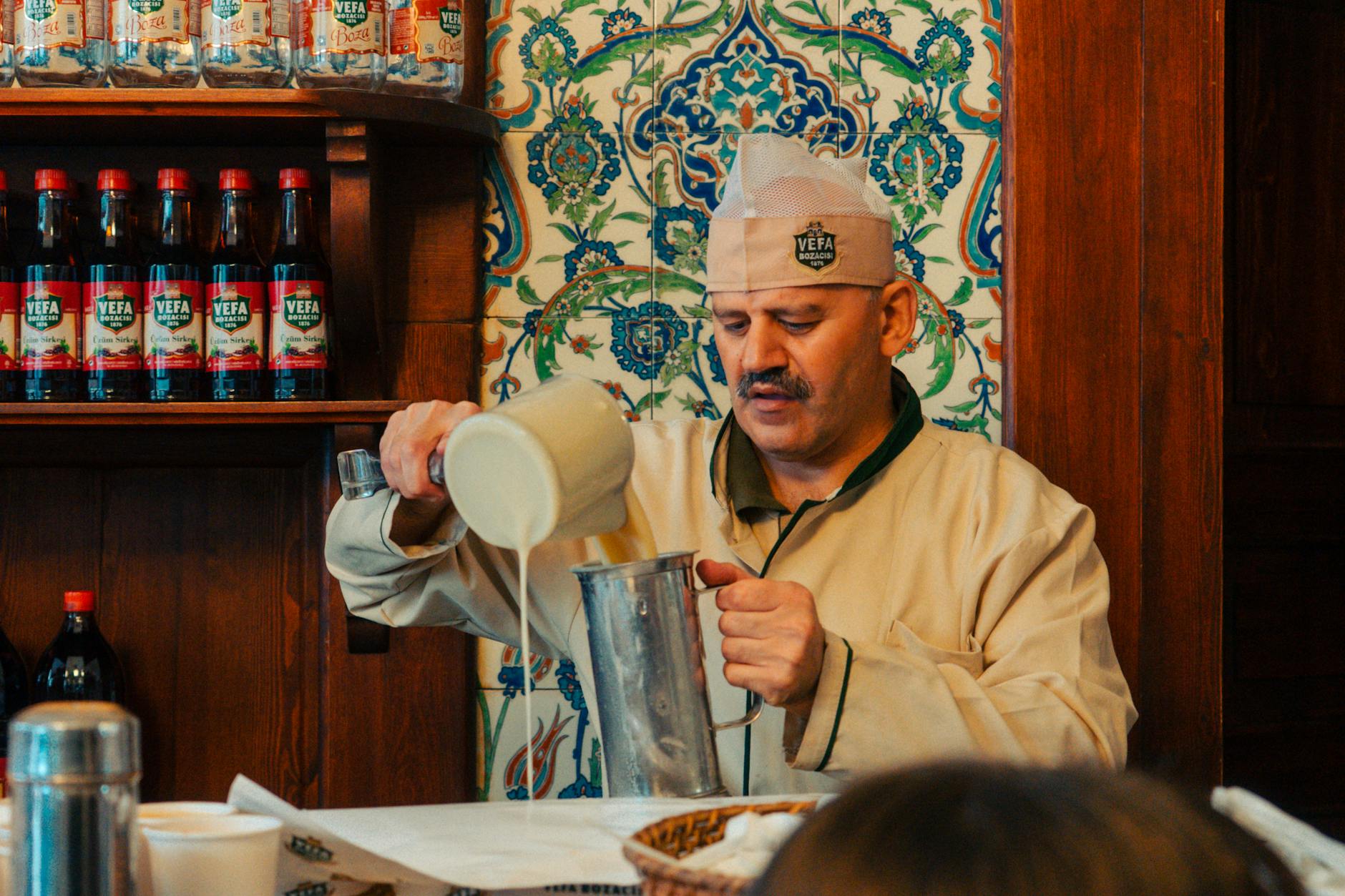 Maestro artesano sirviendo la bebida fermentada boza en el local original de Vefa.
