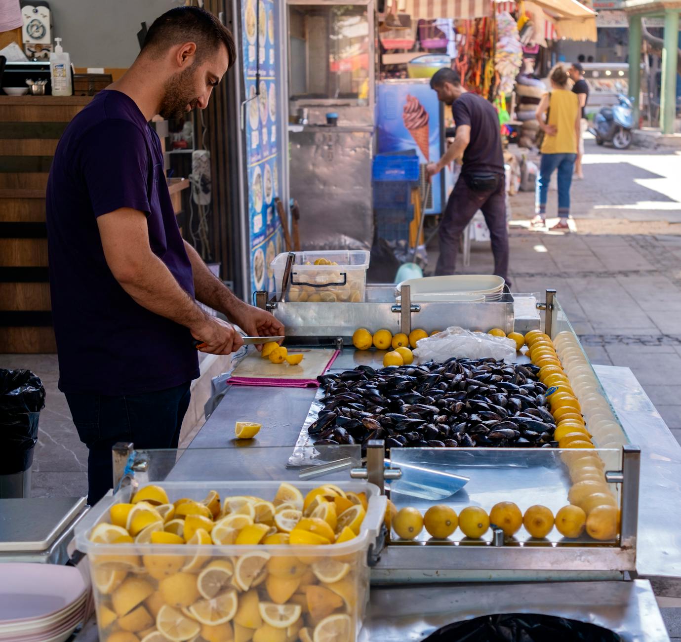 Vendedor callejero preparando midye dolma con limones frescos en un puesto tradicional turco.