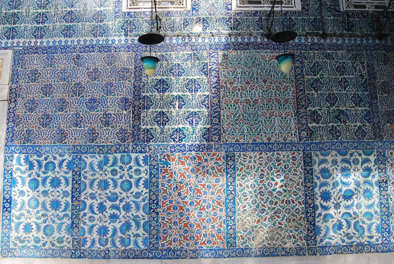 Muro interior de la Mezquita de Rüstem Paşa cubierto con intrincados azulejos otomanos Iznik en tonos de azul, verde y naranja.