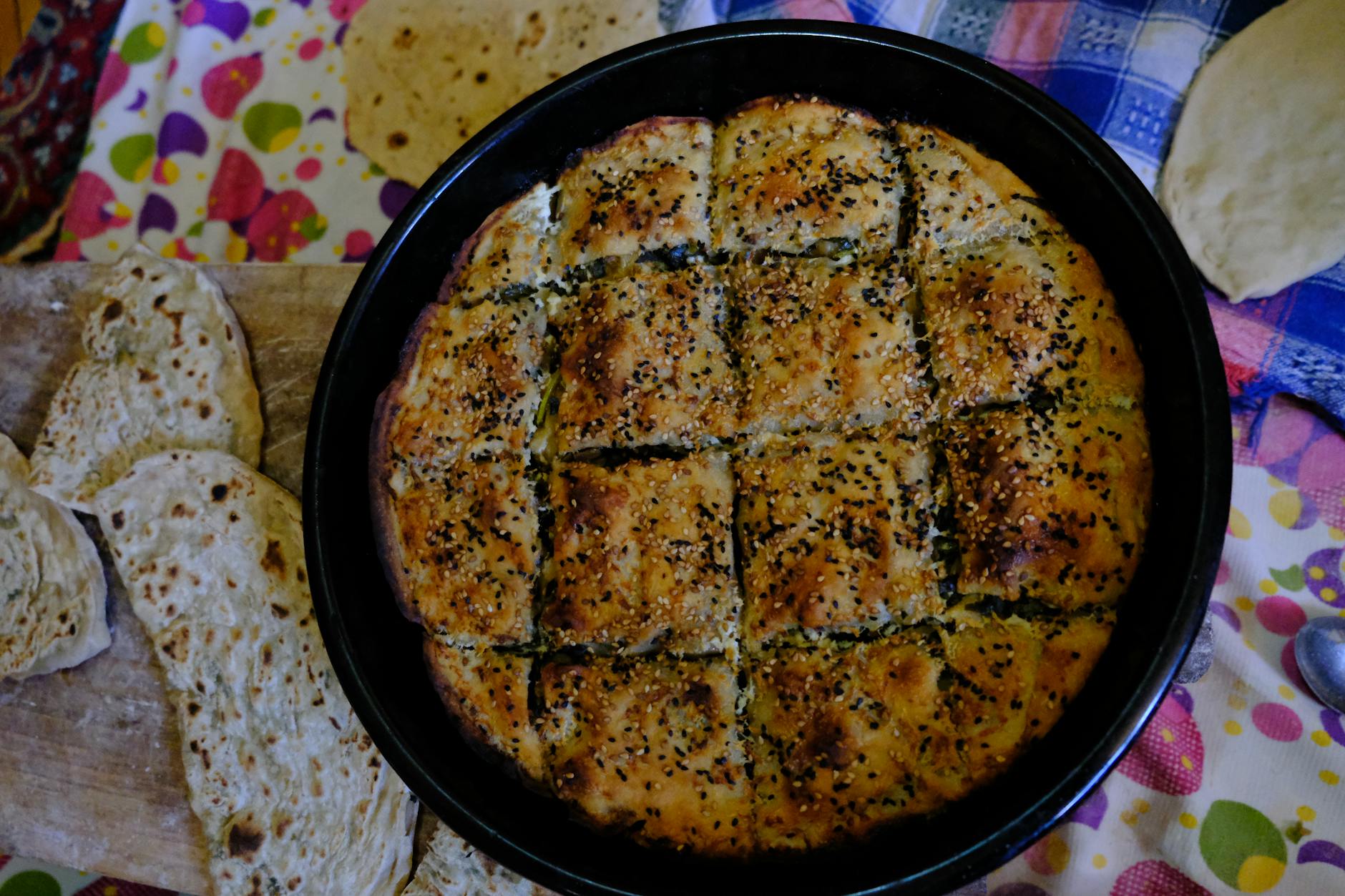 Bandeja de pastel salado turco con semillas de sésamo recién horneado sobre la mesa.