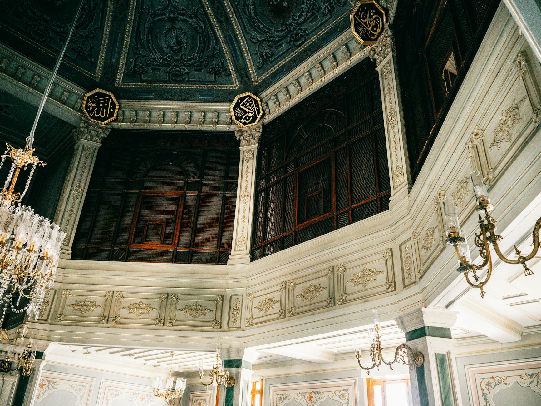 Interior de la mezquita Yıldız Hamidiye con techos azules y caligrafía islámica dorada.